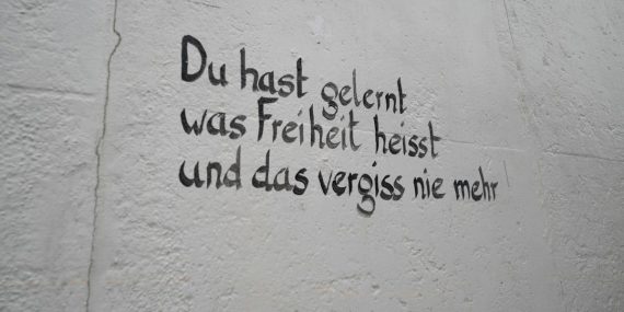 German text on a textured wall